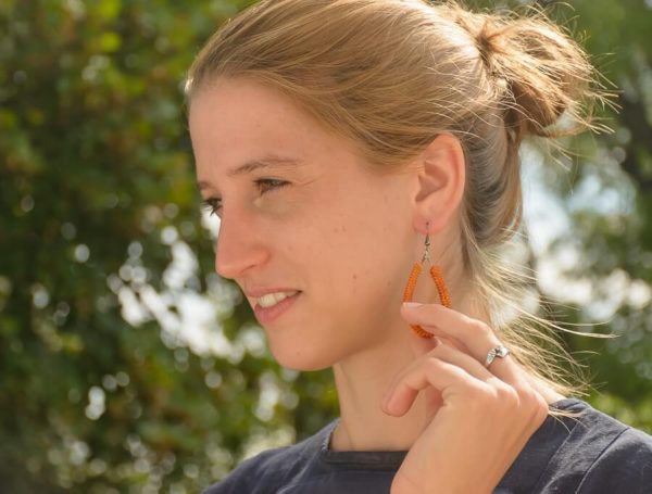 csepp alakú narancs bőr fülbevaló antikolt ékszeralaktrésszel női modell fülében