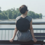 Lulla kollekció kör alakú fekete színű variálható bőr válltáska és hátizsák női modell hátán