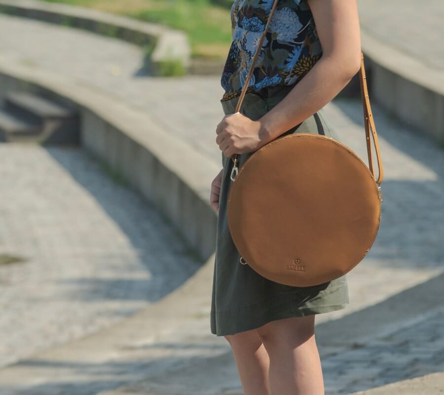 lulla nevű kör alakú natúr színű marhabőr variálható desing táska női modell vállán