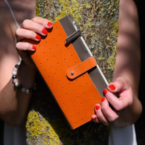mitta grafit, narancs bőr pénztárca modell kezében