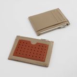 Mitta mini leather wallet with a perforated card pocket on one side and 3 card pockets and a compartment on the other side. Beige - orange color combination. With a zippered compartment for small items.
